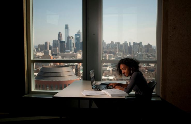Image of student studying next to window
