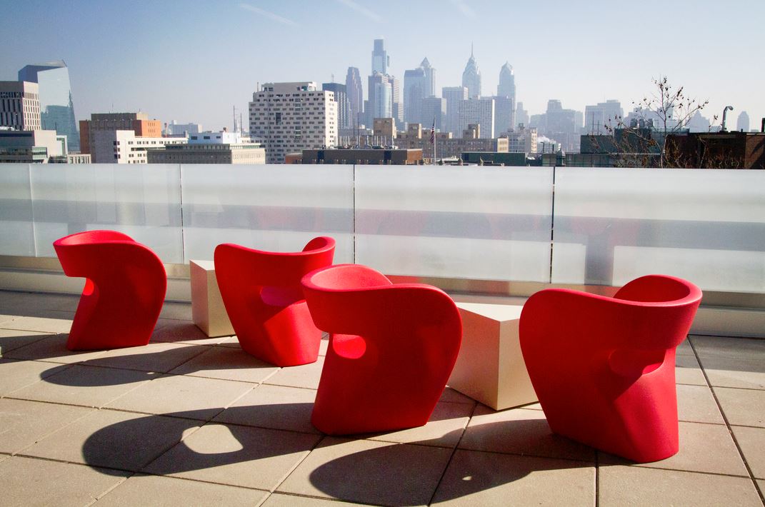 Red chairs on a patio overlooking a city view